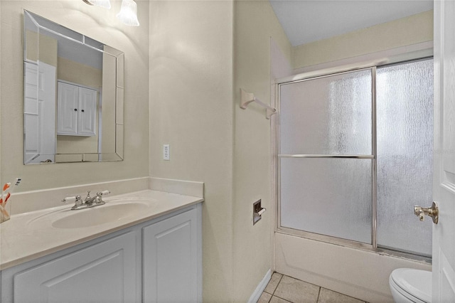 full bathroom featuring toilet, tile patterned flooring, vanity, and combined bath / shower with glass door