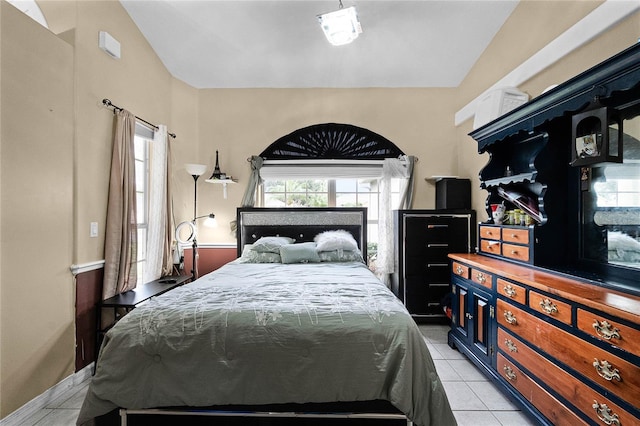 bedroom with light tile patterned floors and vaulted ceiling