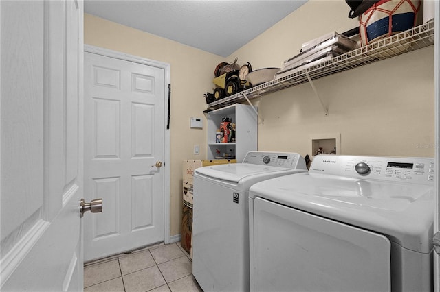 laundry area featuring washer and clothes dryer, light tile patterned flooring, and a textured ceiling