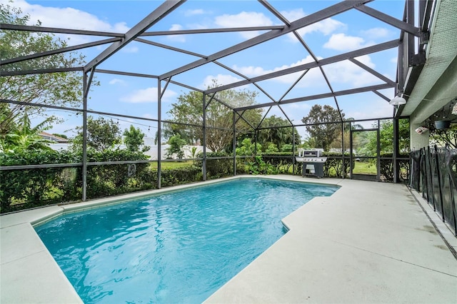 view of swimming pool with a lanai, a grill, and a patio area