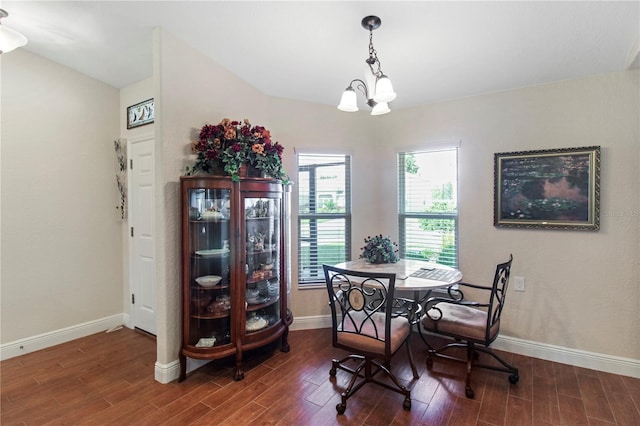 dining area with dark hardwood / wood-style flooring and a chandelier