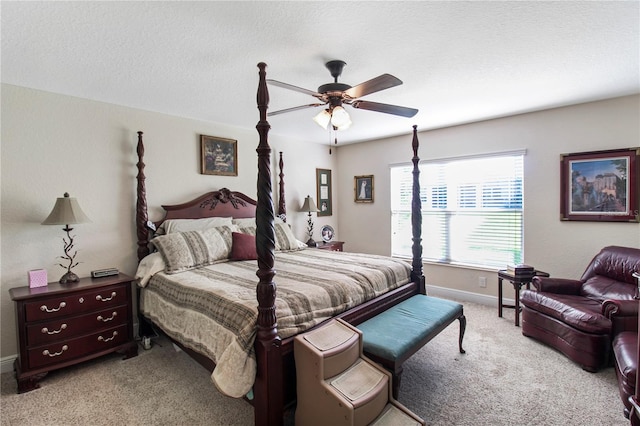 carpeted bedroom featuring ceiling fan and a textured ceiling