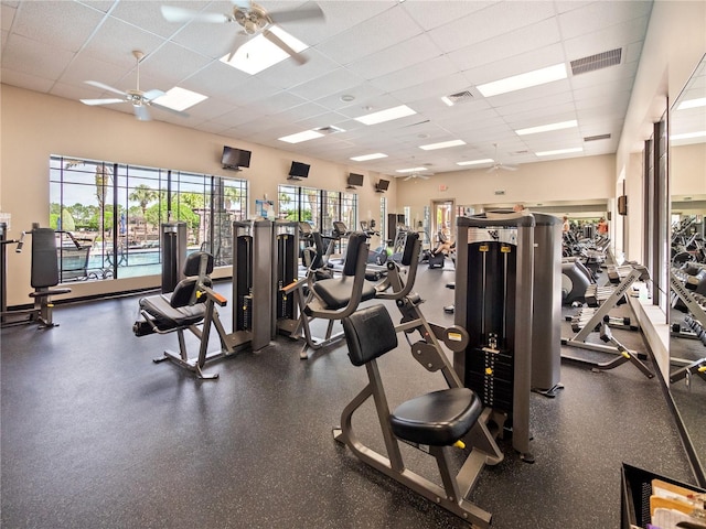 exercise room with ceiling fan and a paneled ceiling