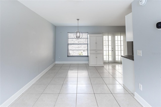 tiled spare room featuring french doors