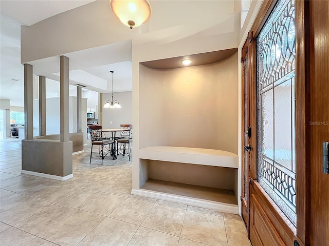 entryway featuring a chandelier, light tile patterned floors, and plenty of natural light