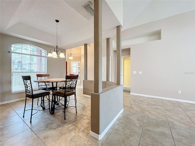 tiled dining area featuring an inviting chandelier and a textured ceiling