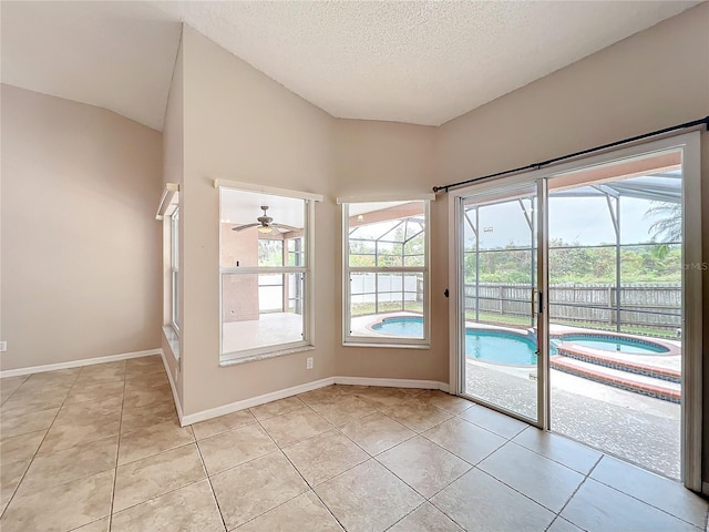 doorway featuring ceiling fan, high vaulted ceiling, a textured ceiling, and light tile patterned floors