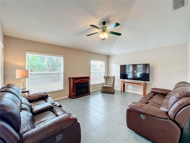 tiled living room with a textured ceiling and ceiling fan