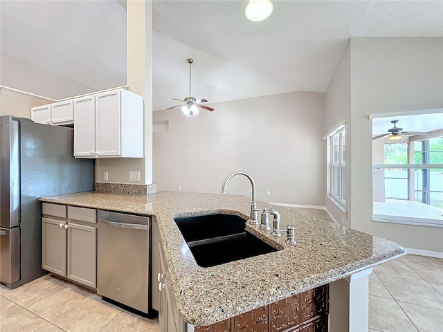 kitchen with appliances with stainless steel finishes, sink, kitchen peninsula, white cabinetry, and high vaulted ceiling