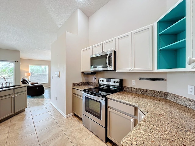 kitchen with sink, appliances with stainless steel finishes, a textured ceiling, and light tile patterned floors