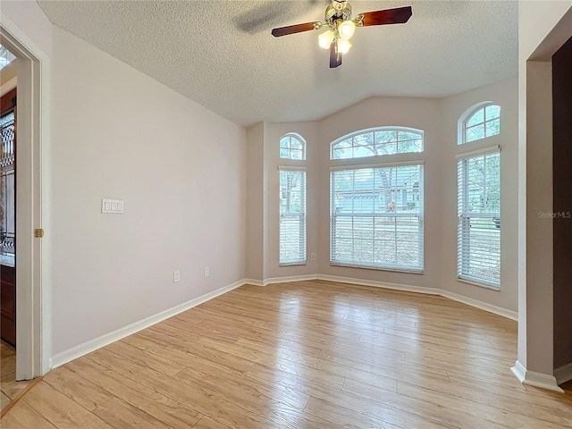 spare room featuring light hardwood / wood-style flooring, a textured ceiling, plenty of natural light, and ceiling fan