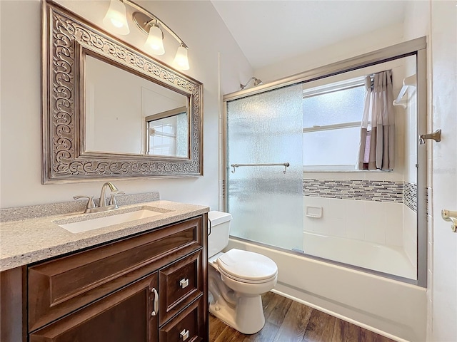 full bathroom with vanity, hardwood / wood-style floors, enclosed tub / shower combo, and toilet