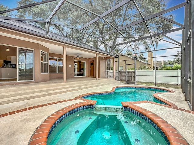 view of swimming pool featuring a patio area, a lanai, an in ground hot tub, and ceiling fan