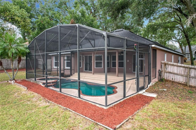 back of property with a lawn, a patio, a fenced in pool, and a lanai