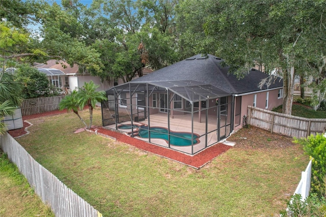 view of pool with a yard, a patio, glass enclosure, and an in ground hot tub