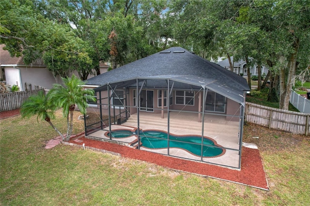 view of pool with a patio area, a lanai, an in ground hot tub, and a lawn