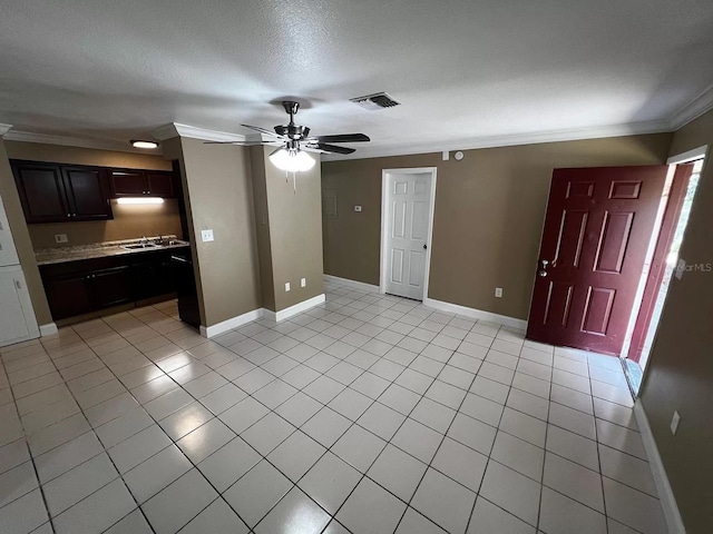 unfurnished living room with ornamental molding, ceiling fan, light tile patterned floors, and a textured ceiling