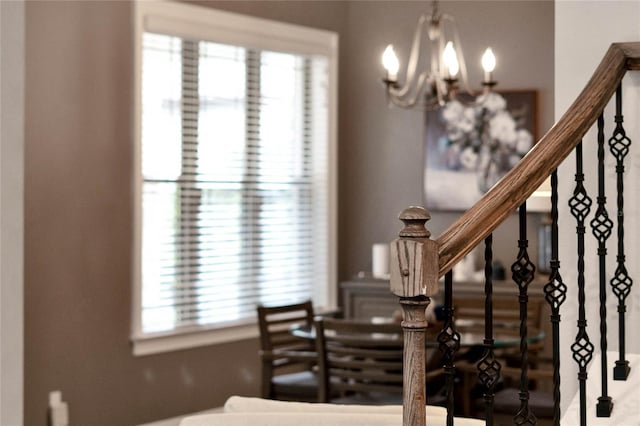 stairs featuring a notable chandelier