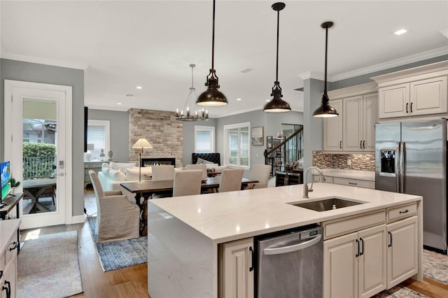 kitchen with light hardwood / wood-style floors, a fireplace, pendant lighting, and stainless steel appliances