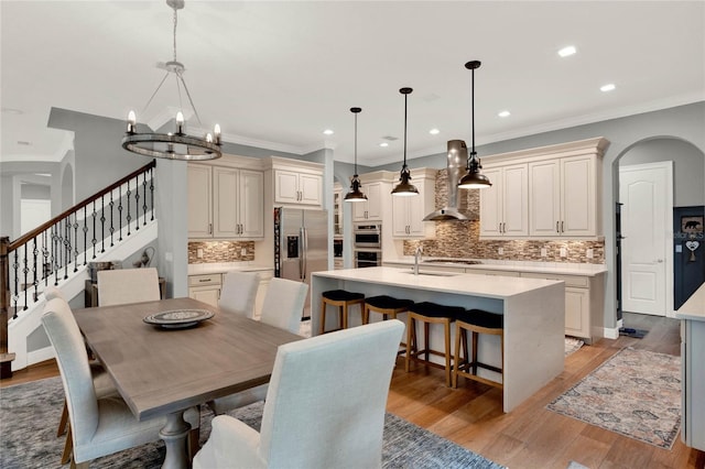 dining space with light hardwood / wood-style flooring, a notable chandelier, and ornamental molding