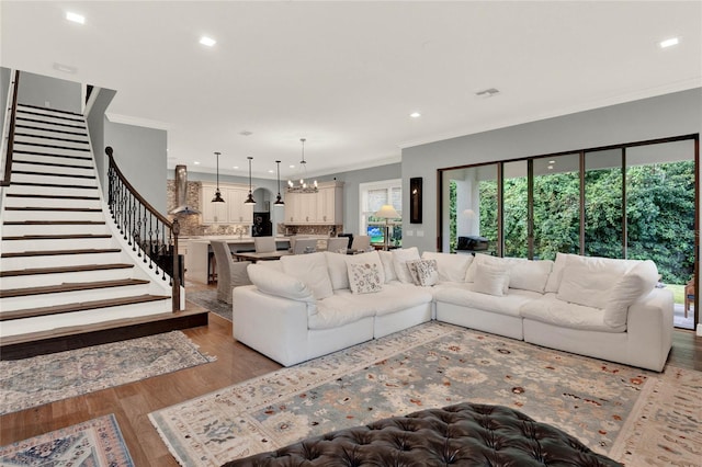 living room with light hardwood / wood-style flooring, a chandelier, and crown molding