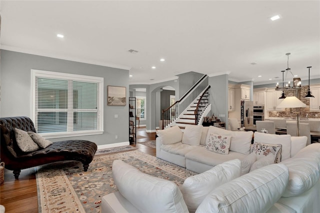 living room with crown molding, light hardwood / wood-style floors, and a notable chandelier