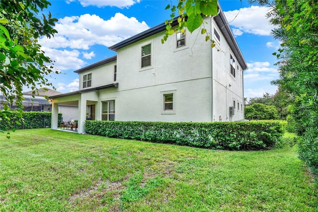 back of house featuring a lawn and a patio area