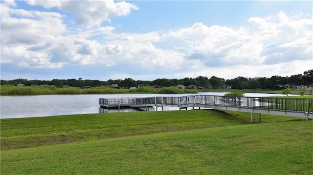 view of dock featuring a lawn and a water view