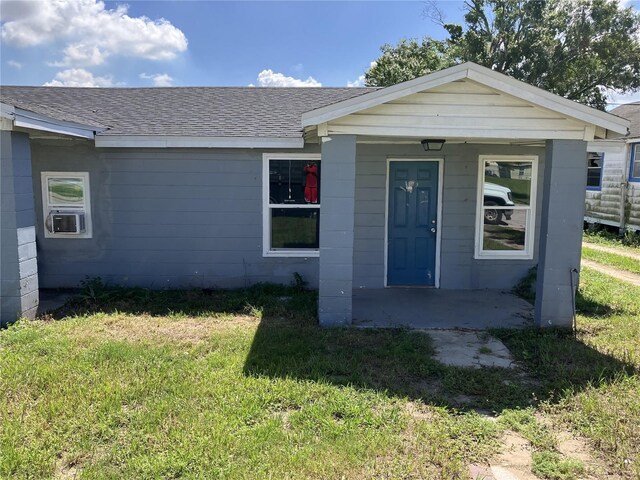 236 Washington Ave, Lake Wales, FL 33853 - doorway to property featuring roof with shingles, a lawn, and a porch