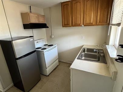 kitchen featuring stainless steel fridge, sink, extractor fan, and white range with electric stovetop