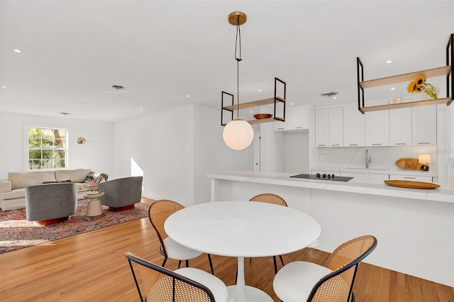 dining space with sink and light hardwood / wood-style floors