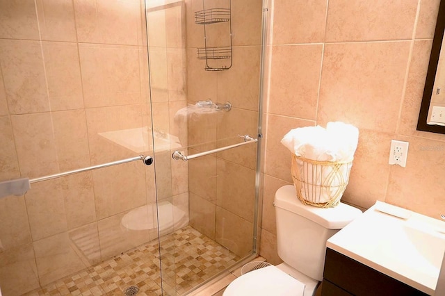 bathroom featuring tile walls, an enclosed shower, vanity, and toilet