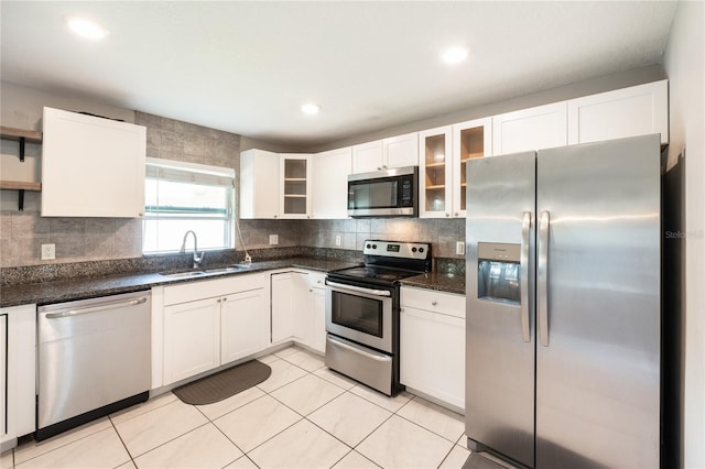 kitchen featuring light tile patterned floors, white cabinetry, dark stone countertops, sink, and stainless steel appliances