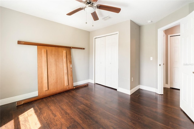 unfurnished bedroom with dark wood-type flooring, a closet, and ceiling fan