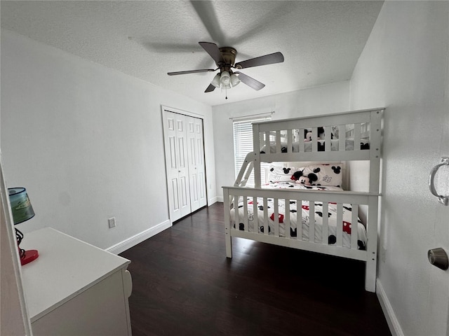 bedroom featuring dark hardwood / wood-style flooring, a closet, a textured ceiling, and ceiling fan