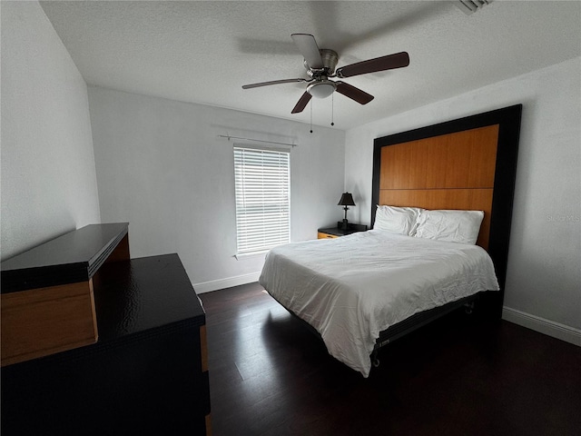 bedroom featuring a textured ceiling, dark hardwood / wood-style floors, and ceiling fan