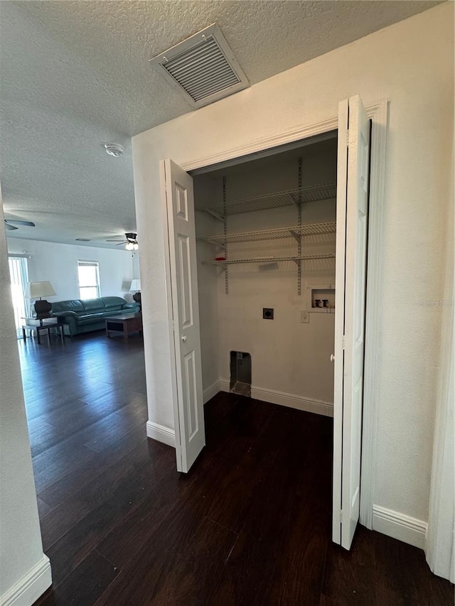 laundry room featuring hookup for a washing machine, a textured ceiling, dark hardwood / wood-style flooring, ceiling fan, and electric dryer hookup