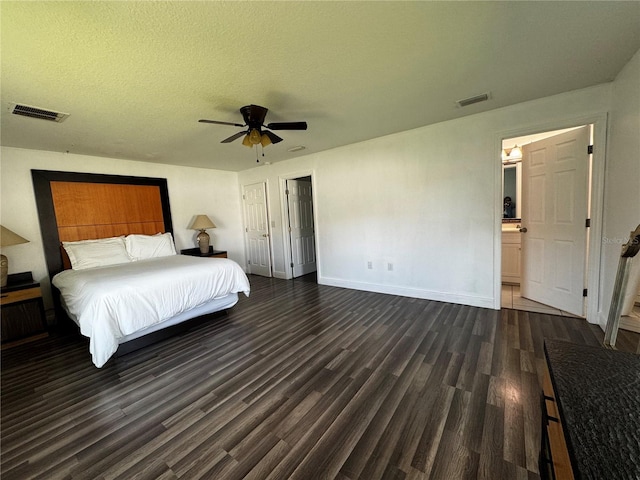 unfurnished bedroom with a textured ceiling, ceiling fan, ensuite bathroom, and dark hardwood / wood-style flooring