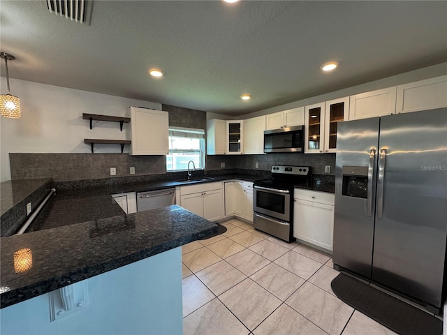 kitchen with white cabinetry, stainless steel appliances, and hanging light fixtures