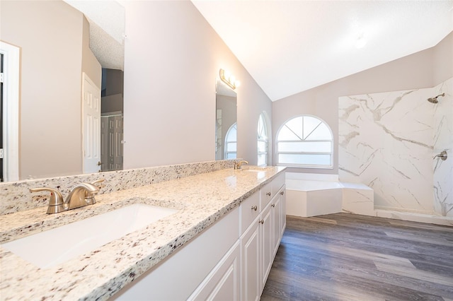 bathroom featuring vaulted ceiling, vanity, a textured ceiling, plus walk in shower, and hardwood / wood-style floors