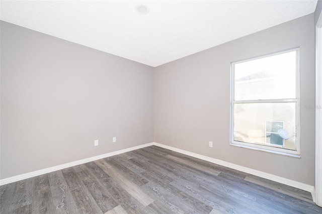 empty room with dark hardwood / wood-style flooring