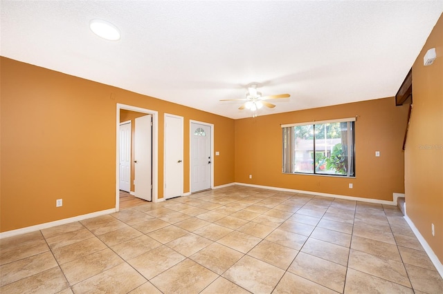 tiled spare room featuring a textured ceiling and ceiling fan