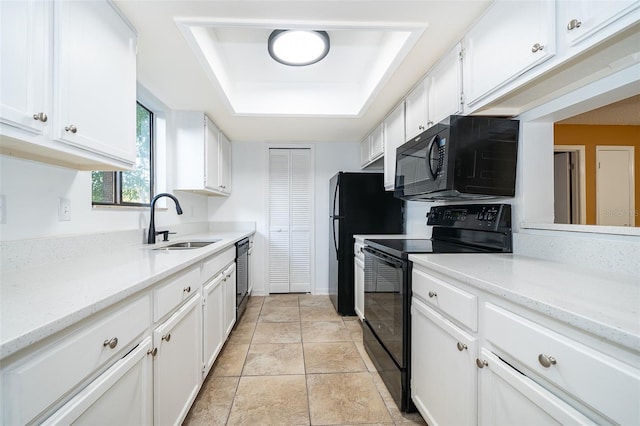 kitchen with white cabinetry, a raised ceiling, light stone countertops, black appliances, and sink