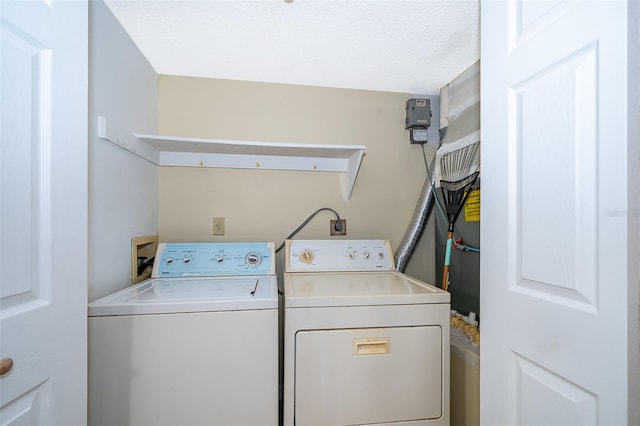 clothes washing area with a textured ceiling and separate washer and dryer