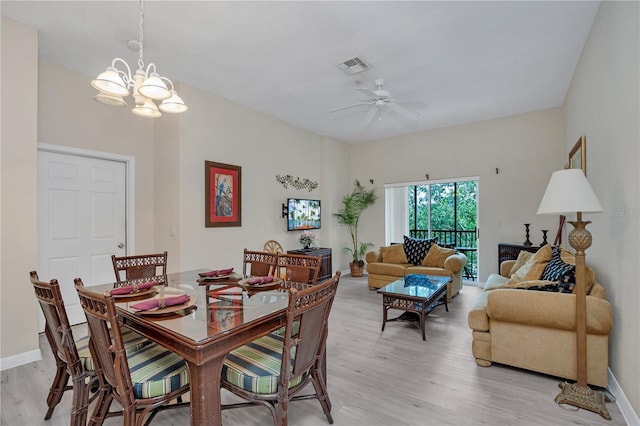 dining area featuring ceiling fan with notable chandelier and light hardwood / wood-style floors