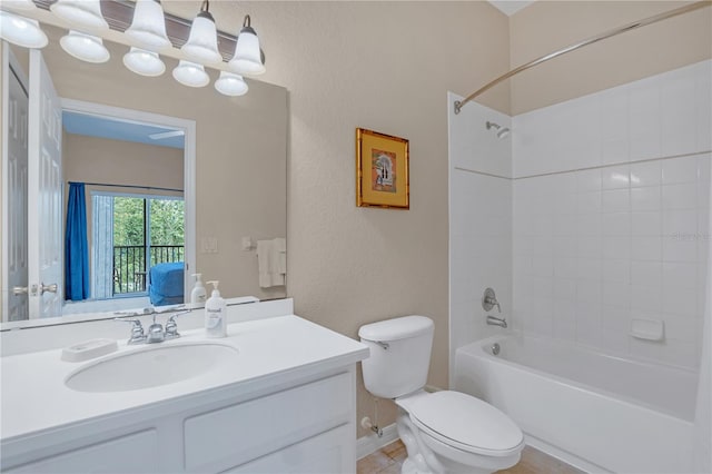 full bathroom featuring tiled shower / bath combo, vanity, and toilet