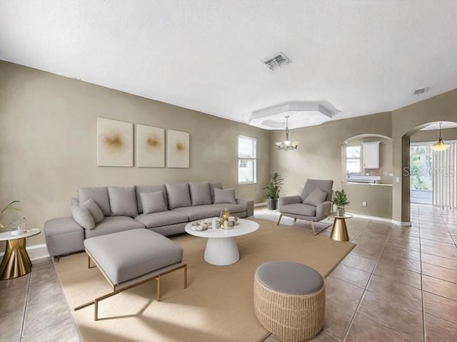 living room with tile patterned flooring, a chandelier, and a wealth of natural light