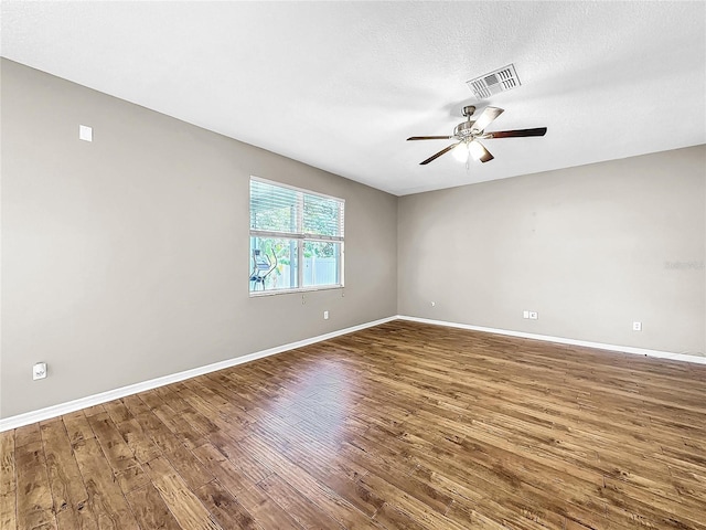 empty room with ceiling fan, a textured ceiling, and dark hardwood / wood-style floors