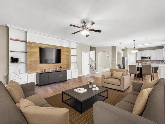 living room with a healthy amount of sunlight, wood-type flooring, and ceiling fan