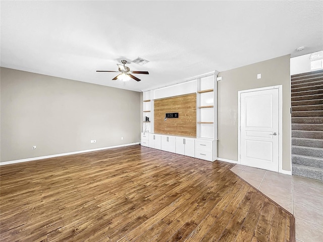 unfurnished living room featuring ceiling fan and hardwood / wood-style flooring